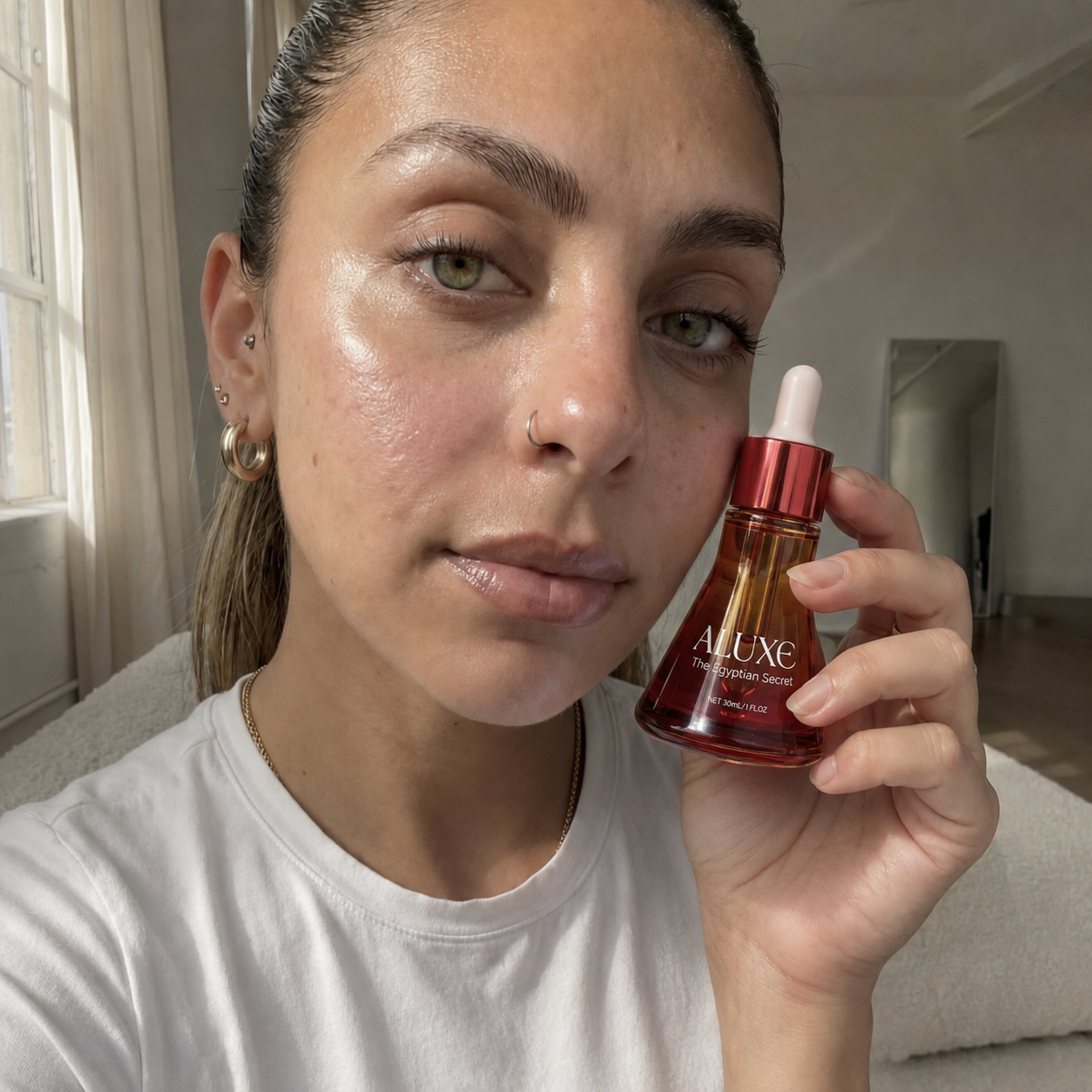 files/Aluxe_Serum_Held_Against_Her_Cheek.png